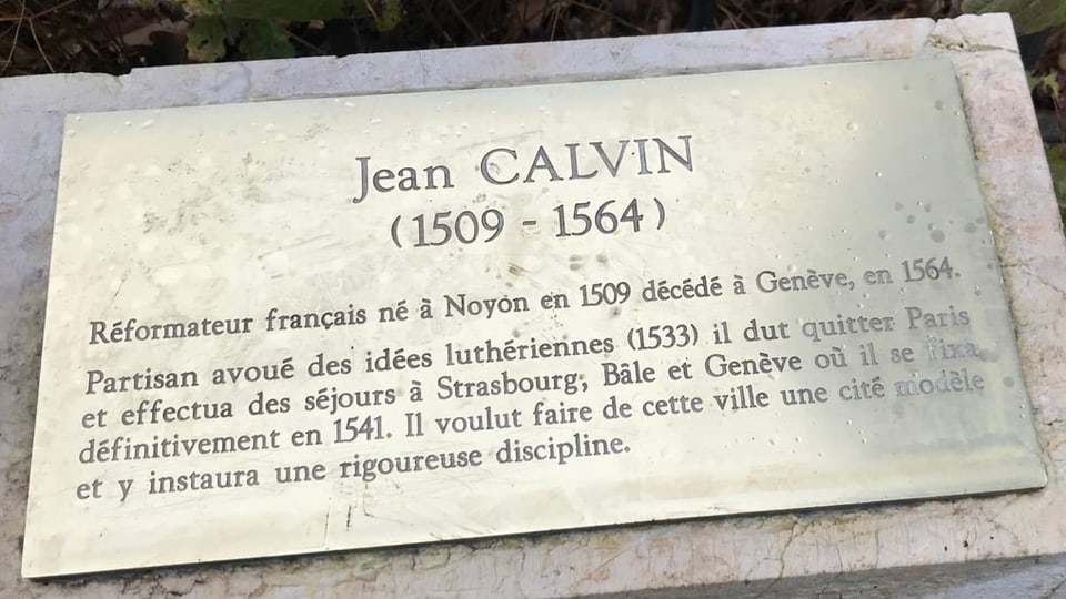 Prägung auf einer Metallplatte auf dem Grab von Jean Calvin.