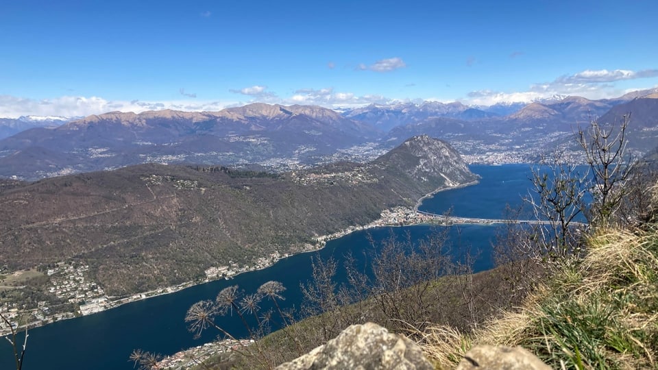 Blick vom Monte San Giorgio auf den tiefblauen Luganersee mit dem Seedamm von Melide.