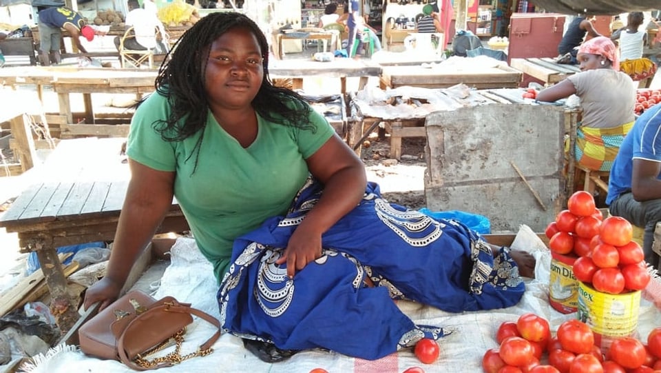 Eine Frau an einem Marktstand mit Tomaten