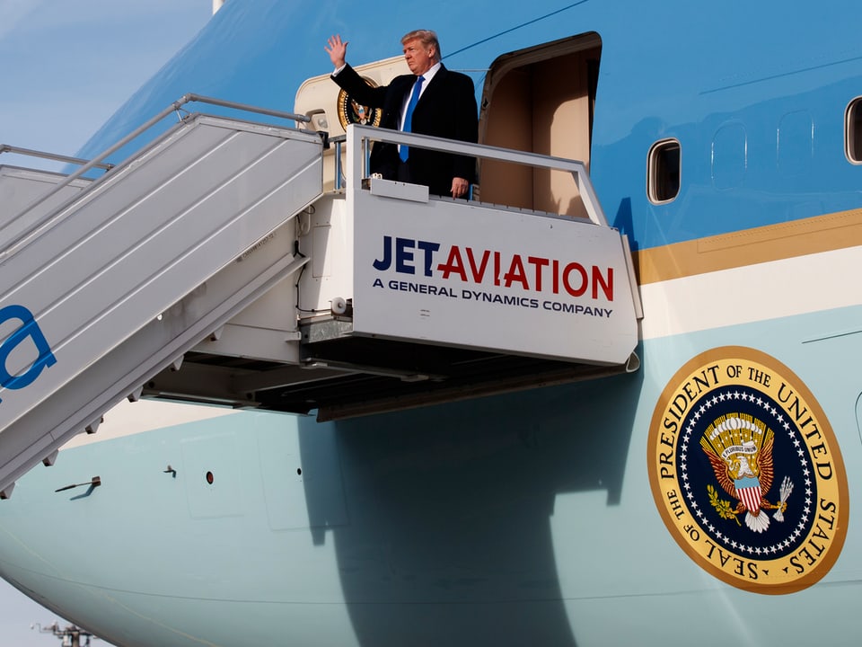 Trump steigt aus Flugzeug.