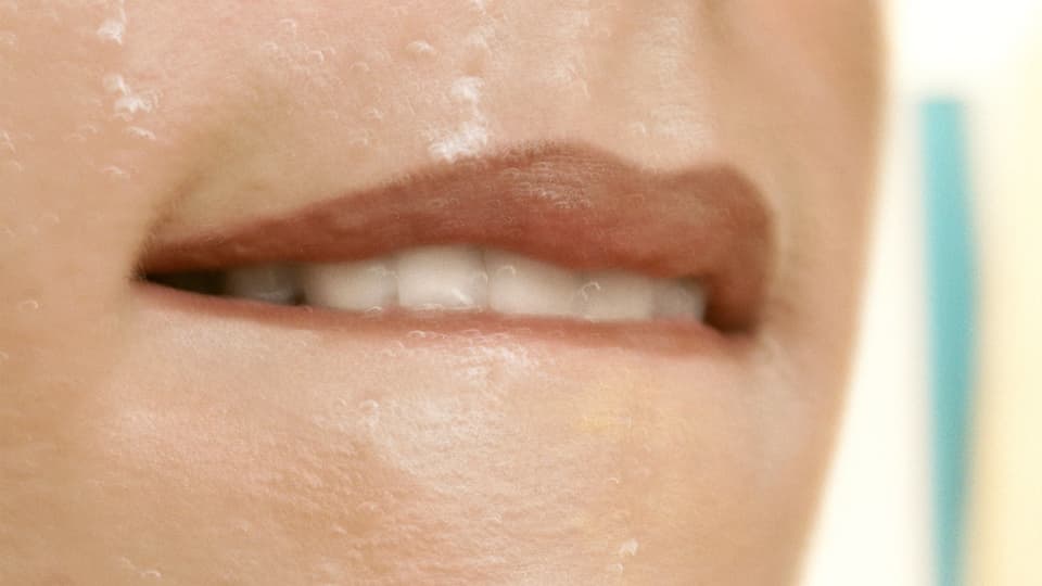 Eine Frau beisst sich mit den Zähnen auf ihre Unterlippe. 