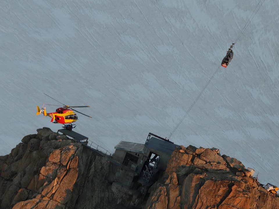 Helikopter und Gondeln bei einer Bergspitze