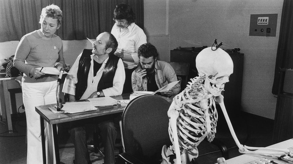 Edith Bussmann (Unterhaltungs-Chefin von Radio Bern), Paul Roland (Regisseur), Jürg Bingler (Redaktor), Rainer Zur Linde (Regisseur und «Schreckmümpfeli»-Stimme bei ihrer schauerlich-schönen Arbeit, unterstützt von einem Skelett.