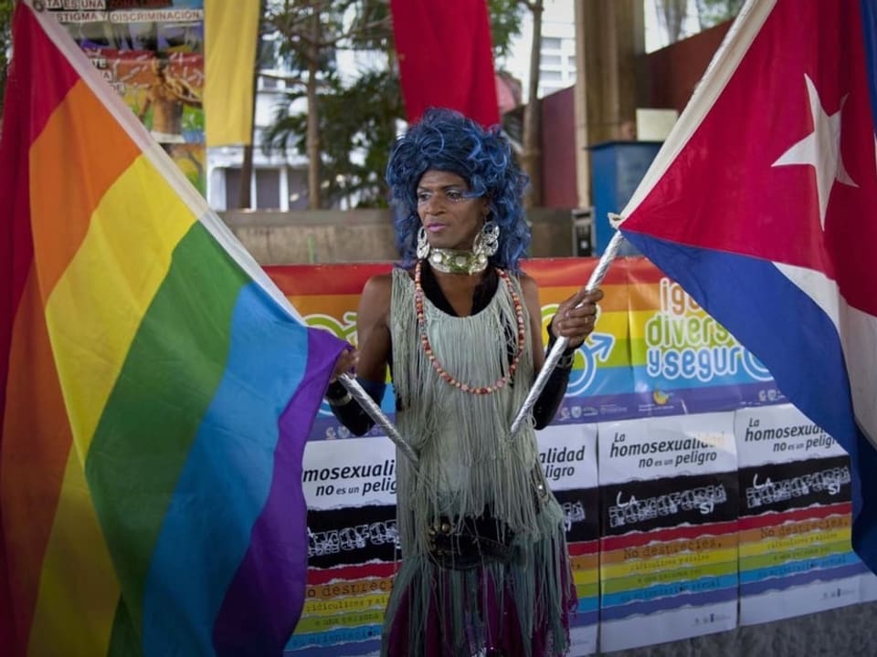 Mann mit Regenbogen- und Kuba-Flagge