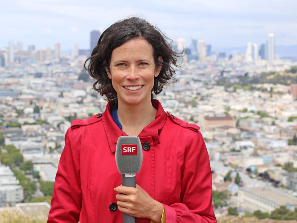 Priscilla Imboden mit Mikrofon, San Francisco im Hintergrund.