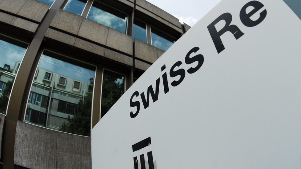 Schwarzer Schiftzug und Logo der Swiss Re auf weisser Tafel vor einem Firmengebäude