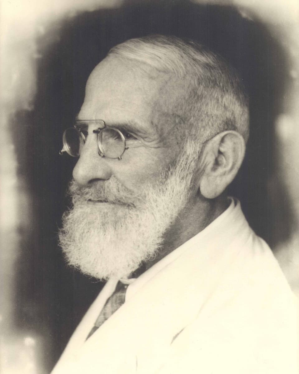 Schwarz-weiss Foto von Maximilian Bircher-Benner mit Bart und Brille im weissen Anzug.