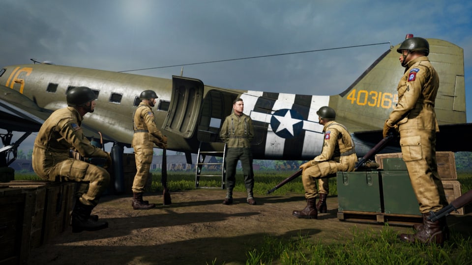 Screenshot aus dem Game «Medal of Honor: Above and Beyond»: Soldaten versammeln sich vor einem Kampfflugzeug.