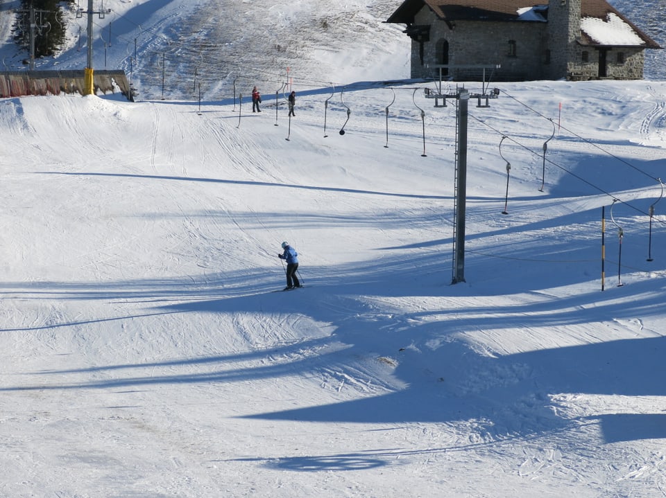 Skilift mit leeren Bügeln und fast keine Skifahrer. 