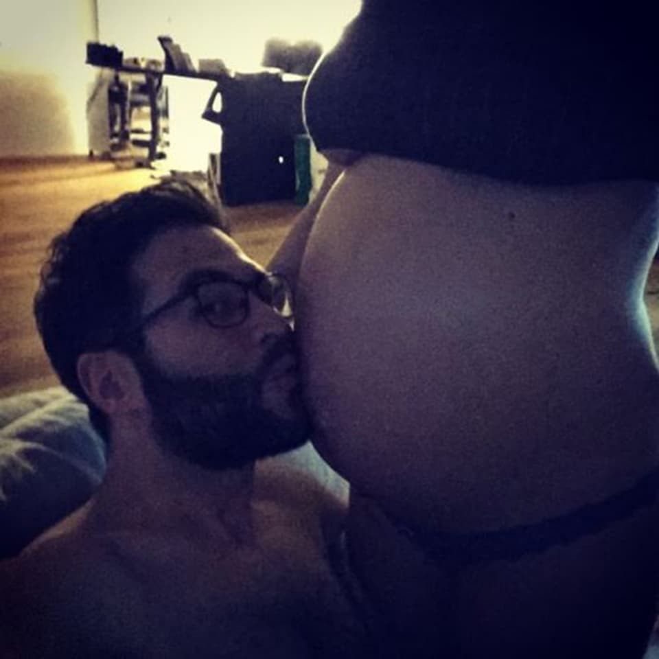 Sandro Cavegn küsst den Babybauch seiner Frau Iva