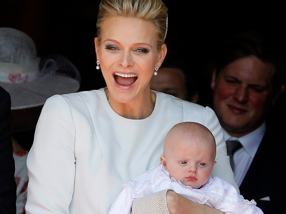 Charlène mit Baby im Arm und lachend.