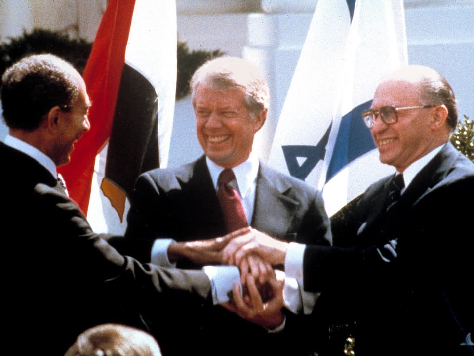 Sadat, Carter und Begin reichen sich die Hand.