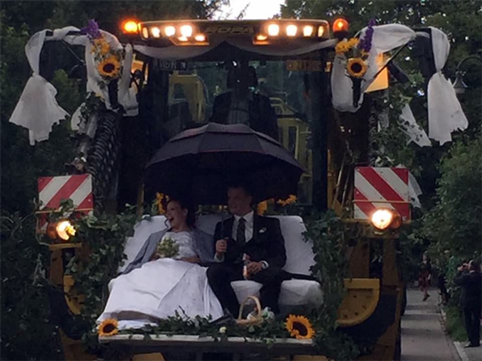 Hochzeitspaar auf einem geschmückten Traktor