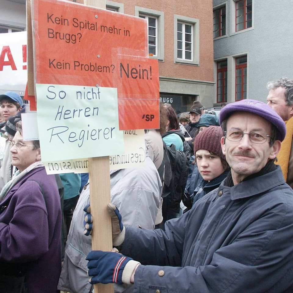 Mann an Demonstration hält ein rotes Schild in die Höhe