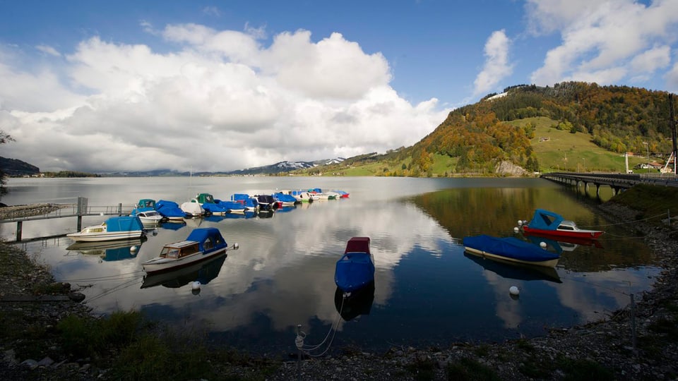 Unter einem Schönwetter-Himmel gibt das Foto den Bild frei auf viele kleine Boote, die auf dem Sihlsee liegen.