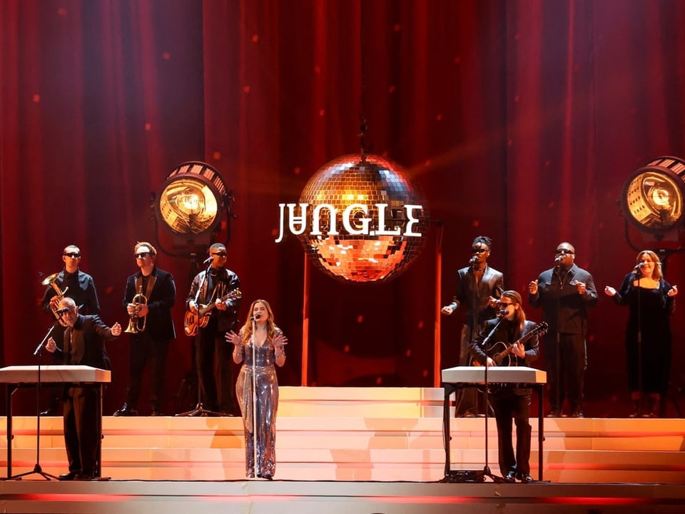 Die Band Jungle ist auf der Bühne zu sehen. Es sind acht Mitglieder zu sehen.
