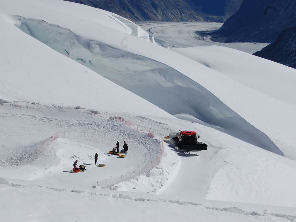 Pistenfahrzeug mit Gletscherspalte im Hintergrund
