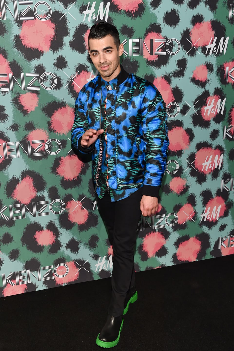 Joe Jonas in einer Blau-Grünen Jacke