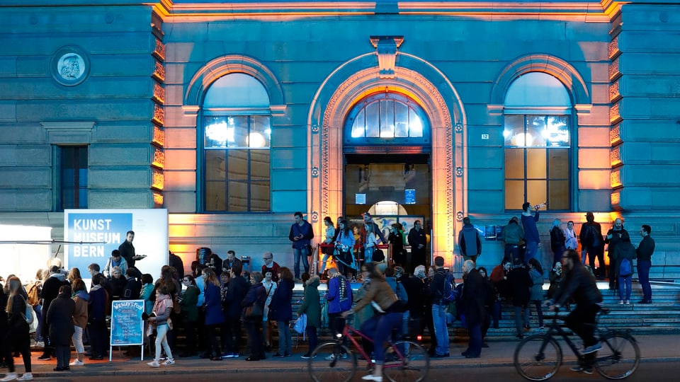 Das beleuchtete Kunstmuseum Bern bei Nacht, davor eine Menschentraube