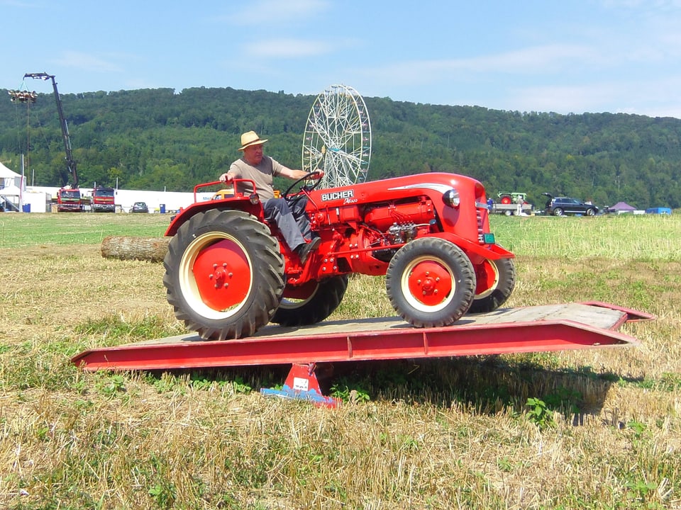 Ein Traktor Bucher D 4000 aus dem Jahr 1961 auf einer Stahlwippe auf einem grünen Feld.
