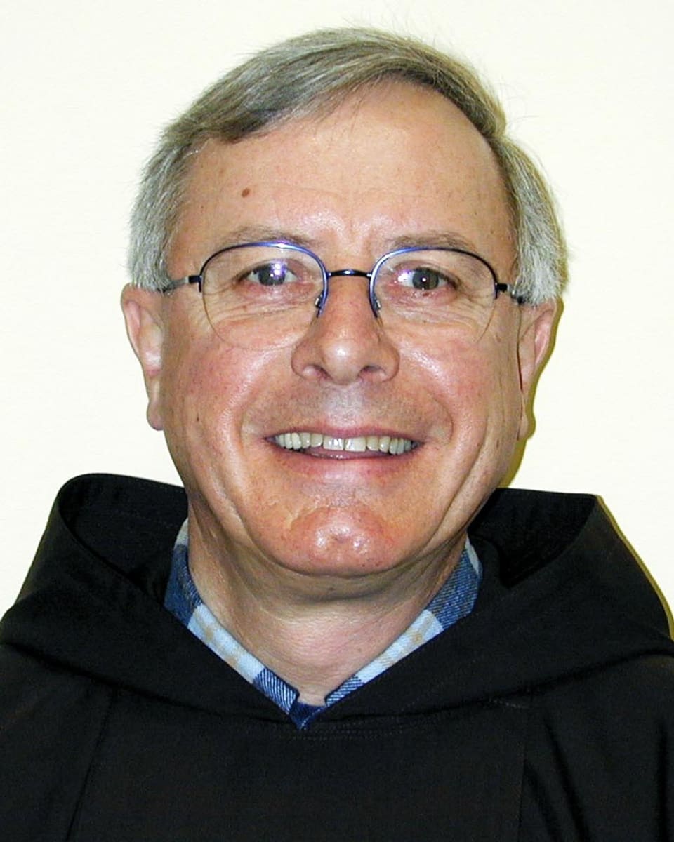 Ein Mann mit Brille und kurzen grauen Haaren lächelt in die Kamera.