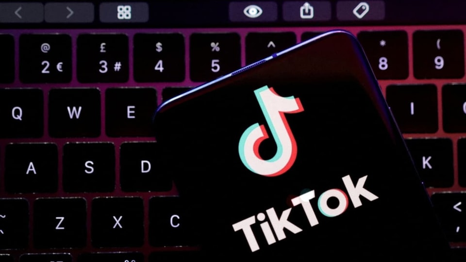 Tiktok-Logo ist zu sehen. Der Hintergrund ist von einer beleuchteten Laptop-Tastatur.