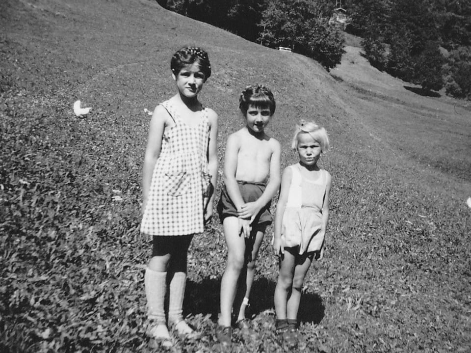 Drei kleine Mädchen auf einer Wiese.
