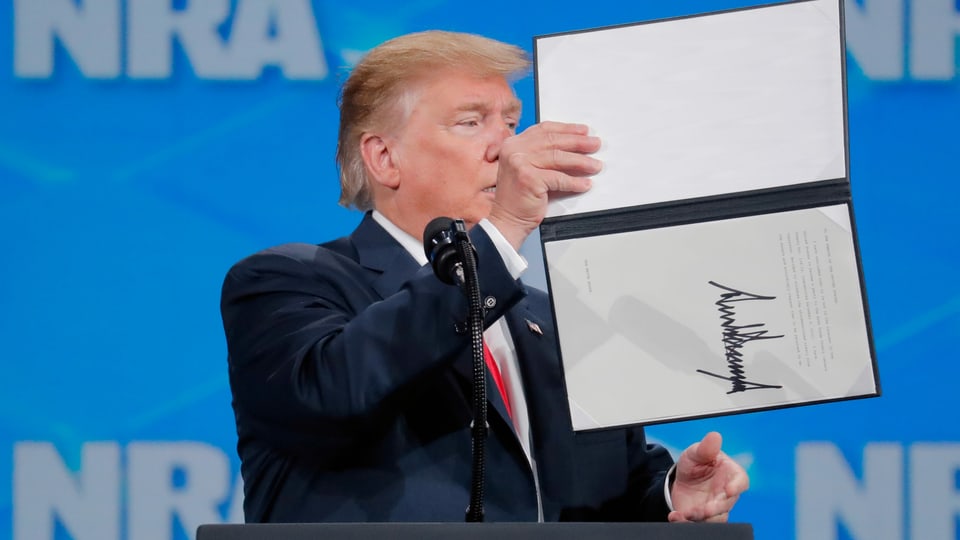 Trump mit unterzeichnetem Dokument