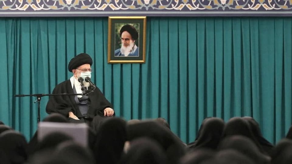 Ali Chameinei, der Oberste Führer Irans, vor einem Bild von Ayatollah Chomeni