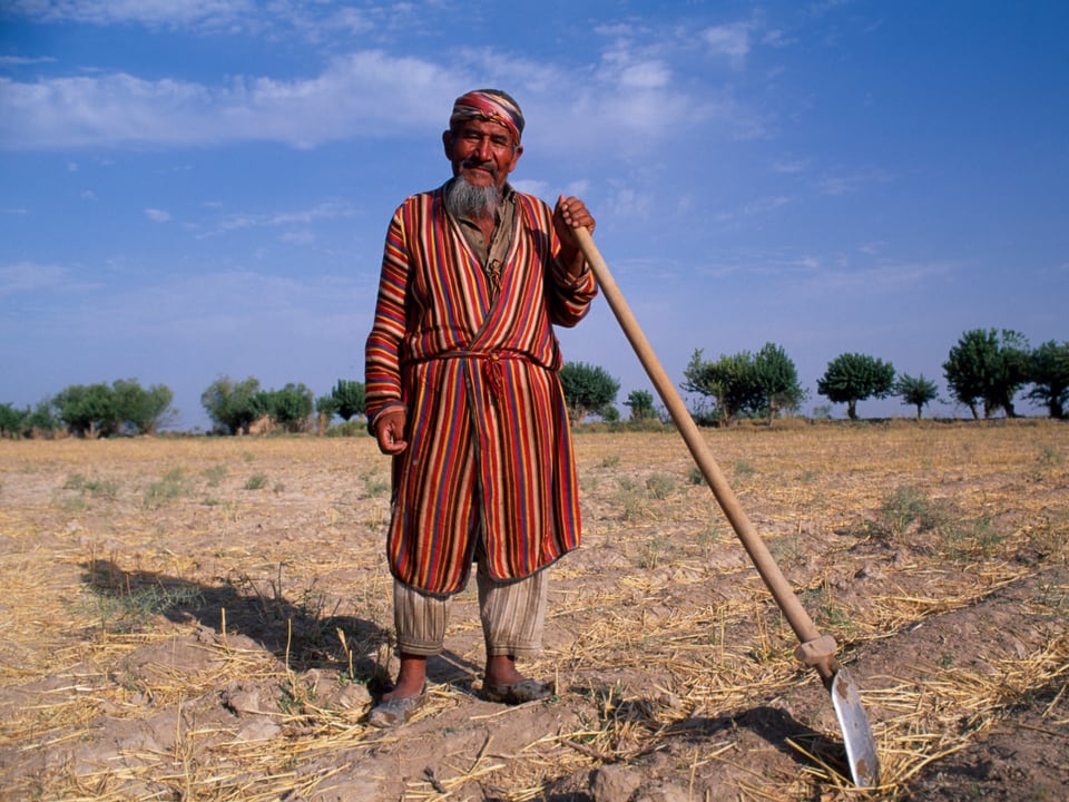 Ein Feldarbeiter im Süden Usbekistans posiert mit einer Schaufel.