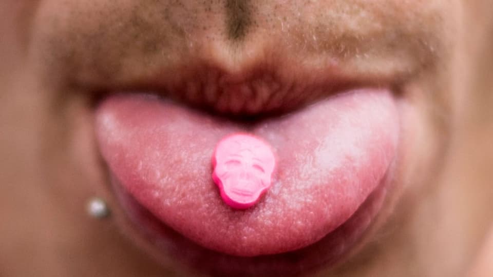 Ein Besucher der Street Parade 2017 zeigt seine MDMA-Pille auf der Zunge..