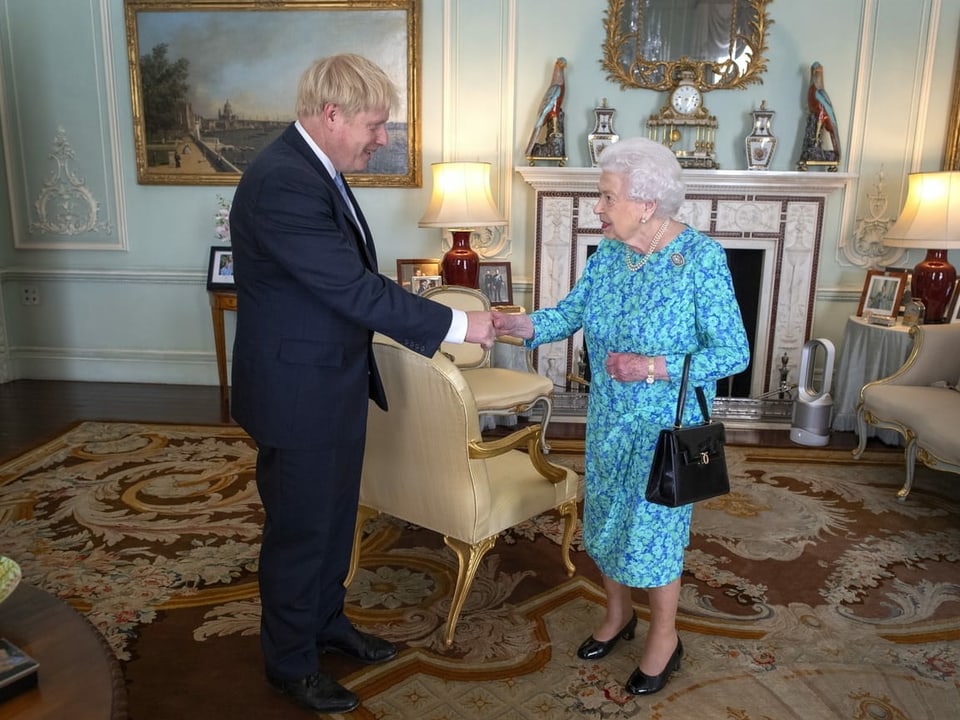 Boris Johnson, im Anzug, streckt der Queen die Hand zur Begrüssung entgegen.