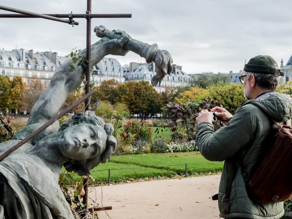 Ein Mann fotografiert die Skulptur Soulevement-Effondrement