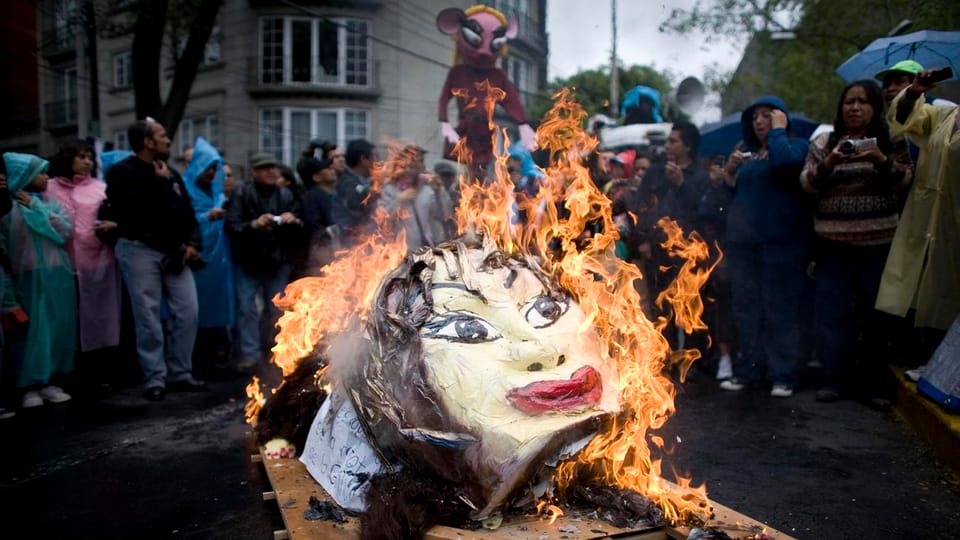 Demonstranten verbrennen während eines Protests einen Kopf Gordillos aus Pappmaché.