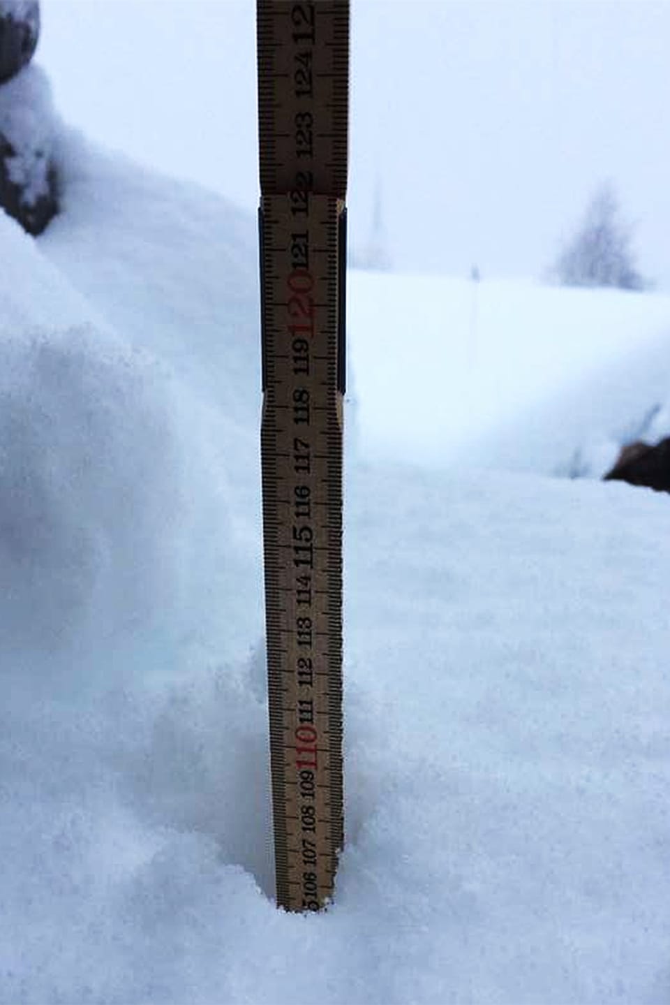Meterstab im Schnee. Ragt bis 110 Zentimeter in den Schnee.