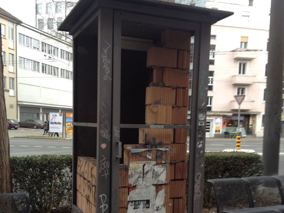 In einer Telefonkabine in Biel sind Ziegelsteine aufgebaut.