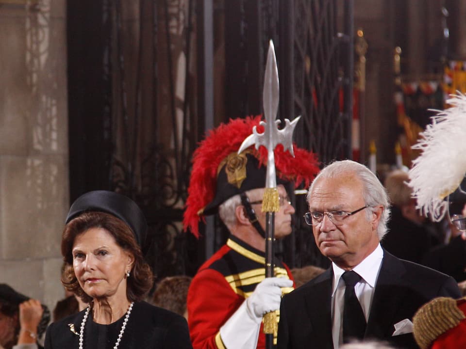Königin Silvia, König Carl Gustav, darum herum Wächter. 
