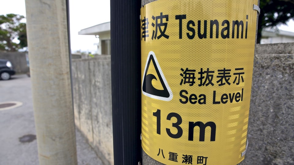 Ein gelbes Tsunami-Warnschild zeigt die Höhe des Standortes über Meeresspiegel an: 13 Meter.