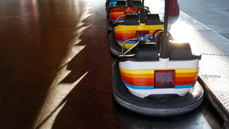Leere Wagen einer Autoscooter-Bahn an einem Jahrmarkt.