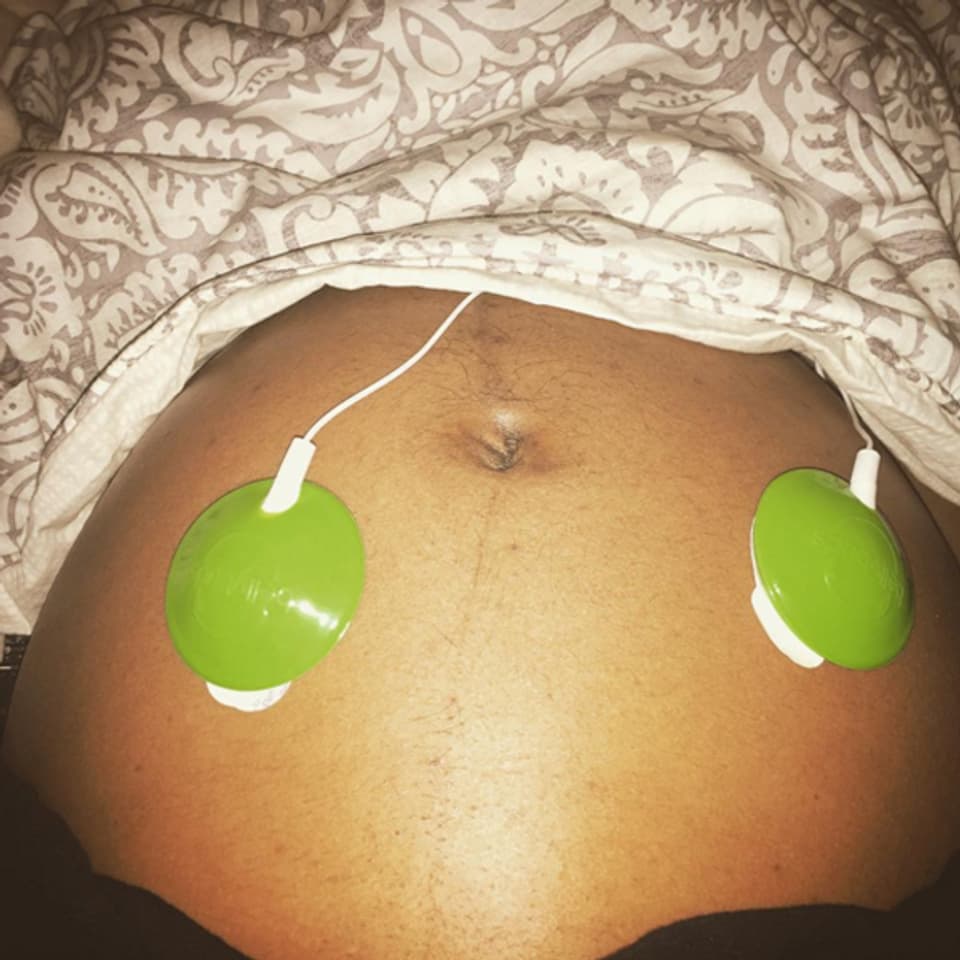 Bauch einer Schwangeren, darauf zwei Lautsprecher.