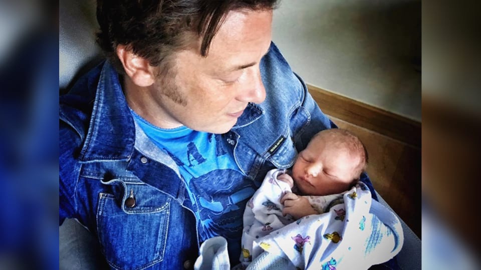 Jamie Oliver trägt sein Baby in den Armen