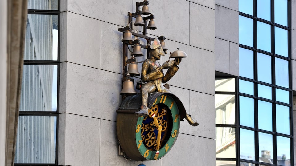 Bild von der Solothurner Uhr, mit einer Figur die darauf sitzt, und mehreren Glocken.