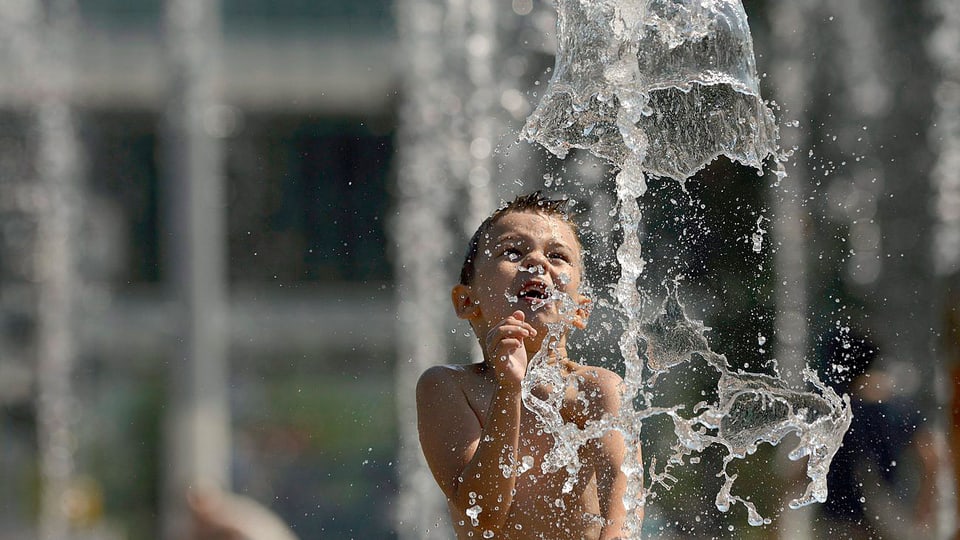 Junge spielt im Wasser.