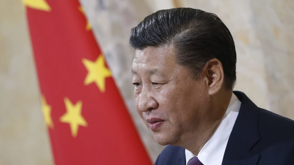 Mann mit Chinaflagge im Hintergrund.