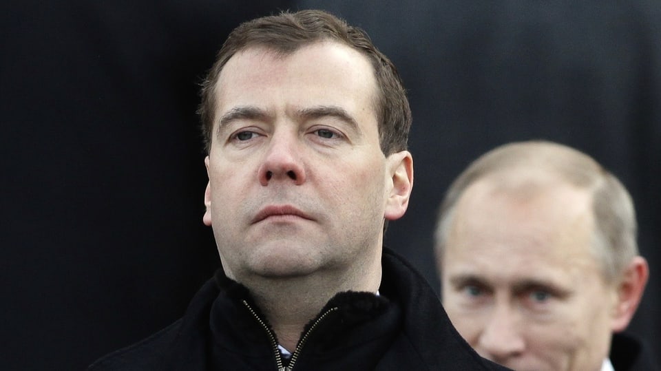 Medwedew schaut streng, hinter im ist Putin zu sehen.