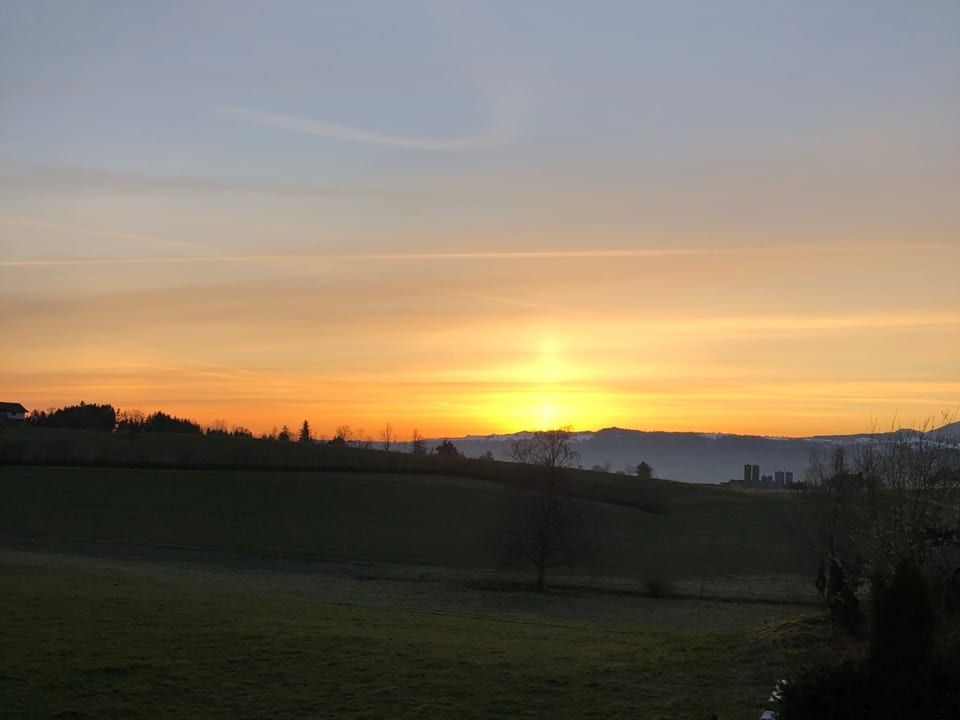 Kurzer senkrechter Strahl über Sonnenaufgang