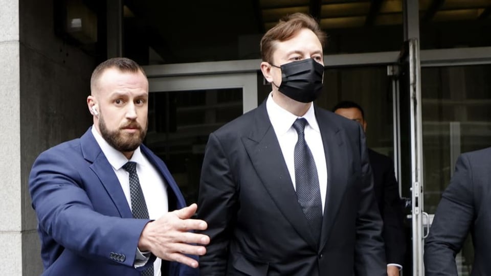 Man sieht wie Elon Musk vor dem Gericht weggeführt wird.