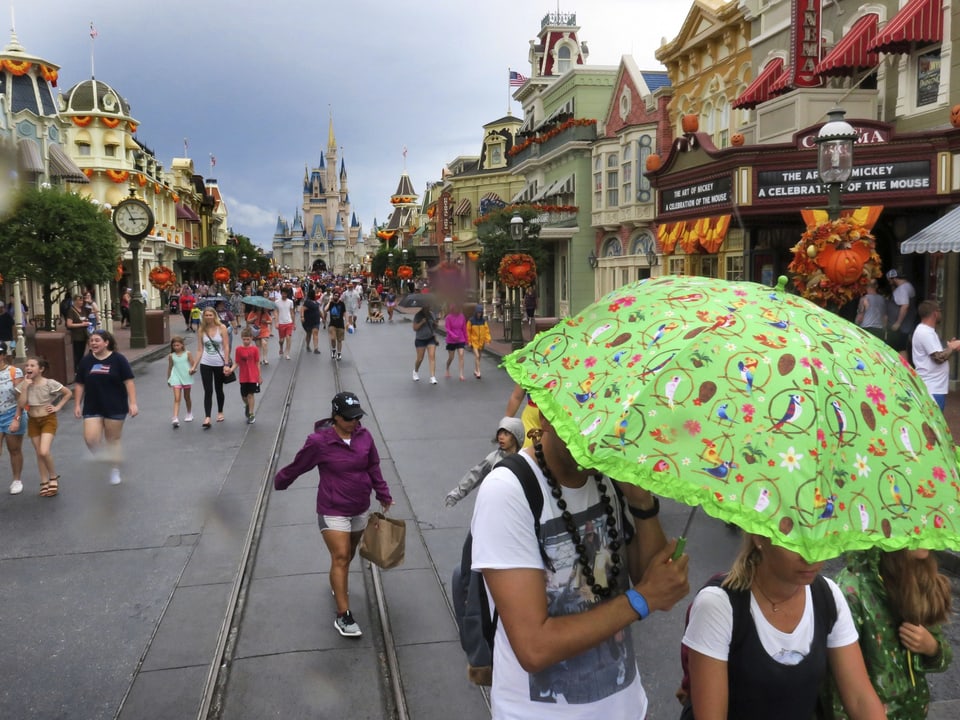 Besucher verlassen Disney Land bei regnerischem Wetter.