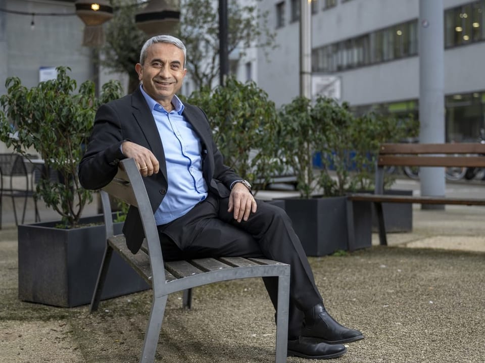 Mustafa Atici sitzt auf einem Stuhl in der Stadt.