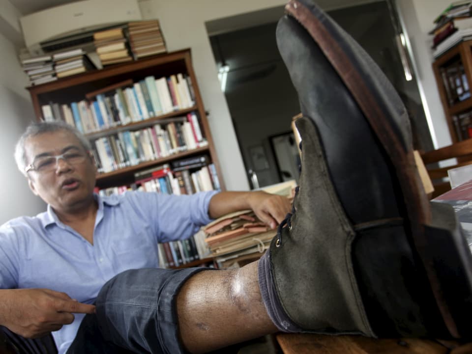Chhang zeigt Folterverletzungen an seinem Bein